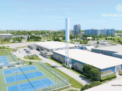 Tennis courts and indoor sports facilities at Iroquois Sports Complex in Whitby with urban skyline and greenery in the background