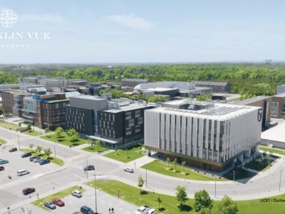Aerial view of UOIT and Durham College campus in Oshawa, featuring academic buildings, tree-lined roads, and parking areas